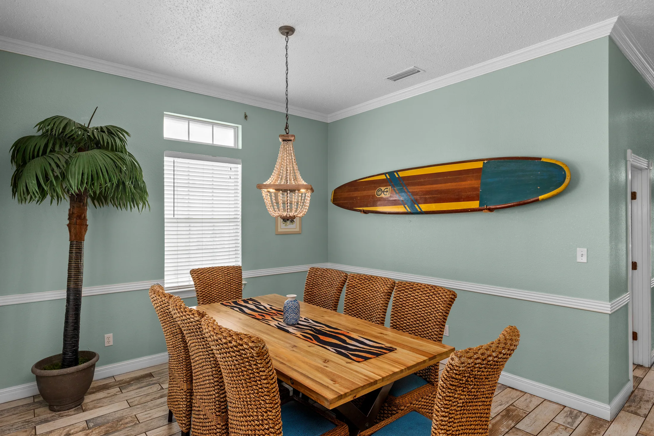 Dining area with coastal surfboard decor at Beach Breeze SPI